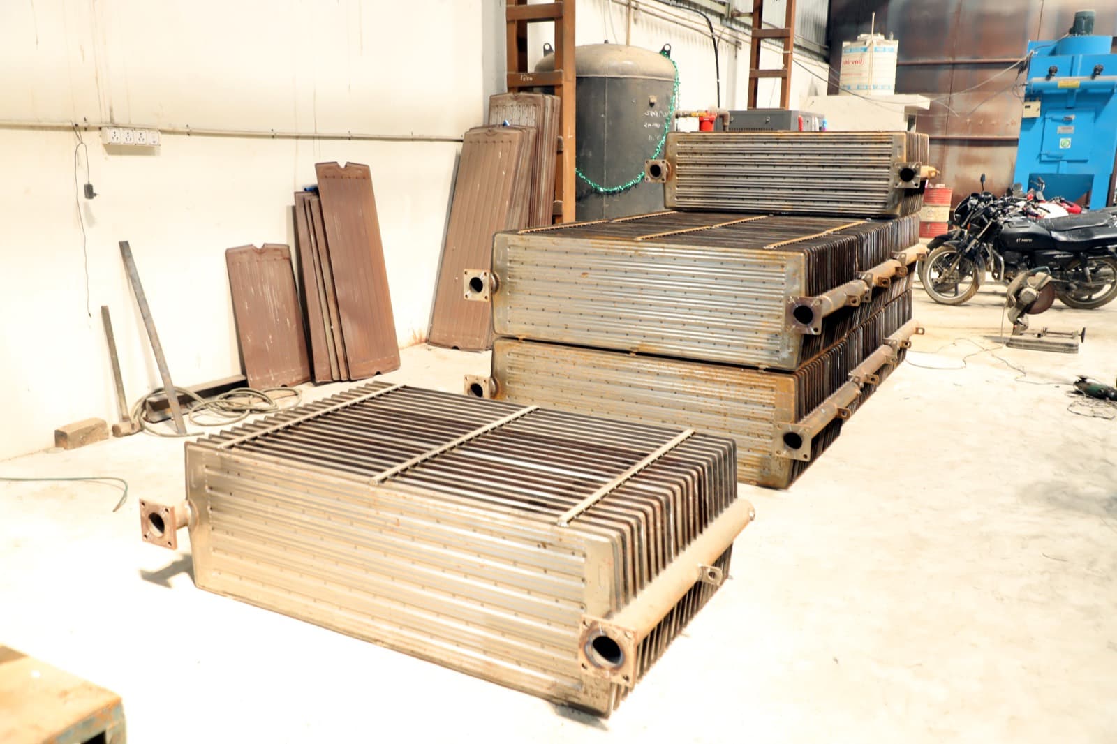 Multiple pressed steel radiator assemblies stacked and ready for finishing